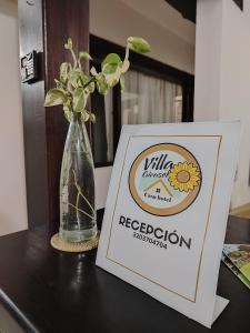 a sign and a vase with flowers in it on a table at Villa Girasol in Villa de Leyva