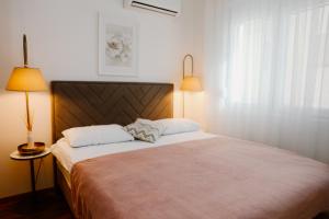 a bedroom with a large bed with two pillows at Bellavista Garden in Baošići