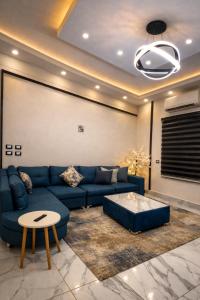 a living room with a blue couch and a table at Luxury Villa Z7 - 6th of October in 6th Of October