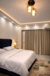 a bedroom with a large white bed and a chandelier at Luxury Villa Z7 - 6th of October in 6th Of October