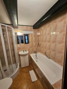 a bathroom with a tub and a toilet and a sink at Ojcówek in Grzymek