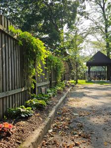 a fence with plants on it next to a gazebo at Ojcówek in Grzymek +40 photos