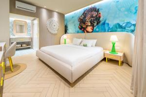 a bedroom with a large white bed and a painting at Trupial Hotel & Casino in Willemstad +47 photos