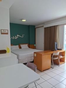 a room with two beds and a desk with a computer at Praia do Canto Apart Hotel in Vitória +15 photos