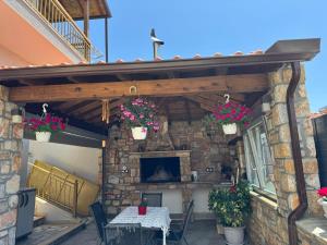 an outdoor patio with a table and flowers in buckets at Megi Cozy Apartment Polygyros Chalkidiki in Polygryos