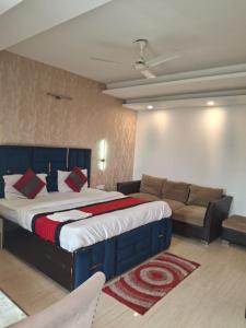 a bedroom with a large bed and a couch at Hotel Royal Stay in Gurgaon
