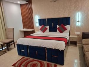 a bedroom with a large bed with blue and red pillows at Hotel Royal Stay in Gurgaon