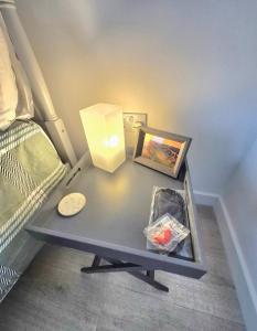 a table with a lamp and a picture on it at Sea Breeze - Sea Scape View in Keiss