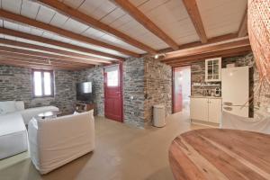 a kitchen and living room with a red door at Stone Wave Kythnos in Loutra