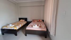 two beds in a small room withermottermottermottermott at Hospedaje Jasmine in Tarapoto