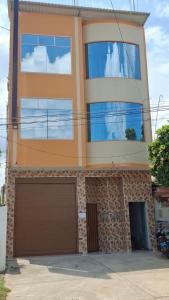 a house with a garage in front of it at Hospedaje Jasmine in Tarapoto +4 photos