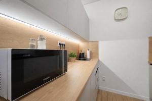 a kitchen with a television and a clock on the wall at Station APA s parkovaním in Michalovce +4 photos