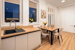 a kitchen with a sink and a table with chairs at Station APA s parkovaním in Michalovce