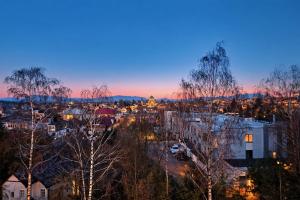 a city skyline at dusk with trees in the foreground at Station APA s parkovaním in Michalovce