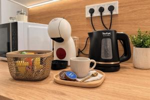 a coffee maker sitting on a counter next to a cup at Station APA s parkovaním in Michalovce