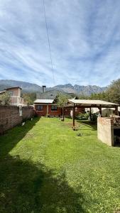 a yard with a building and a grassy field at La Casita de Lorena in El Bolsón