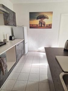 a kitchen with a tree picture on the wall at Gutliegende Wohnung in Maybach