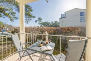 a table and chairs on a balcony with a view of a field at Haus Strandoase 04 in Bansin