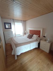 a bedroom with a large white bed and a window at La casa de Somiedo in Pola de Somiedo