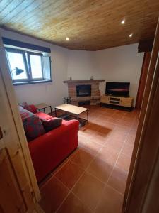 a living room with a red couch and a fireplace at La casa de Somiedo in Pola de Somiedo