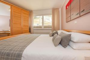a bedroom with a large white bed with pillows at Haus Strandoase 04 in Bansin