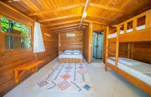 a room with two beds in a wooden cabin at Olympos Mocamp in Kaş