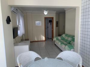 a living room with a couch and a bed and chairs at Apartamento junto mar, bem ventilado e iluminado - Antilhas 679 in Capão da Canoa