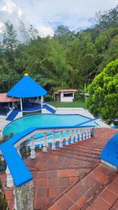 a swimming pool with a blue umbrella and a house at Finca Casa Real la Vega in La Vega