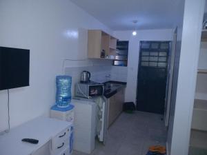 a small kitchen with a sink and a stove at Cavendish Square Studio Unit, Syokimau in Syokimau