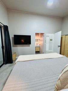 a bedroom with a bed and a flat screen tv at Stillness Suite - Tamarindo - Pinilla - Avellanas - Pool - BBQ in San José Pinilla +28 photos