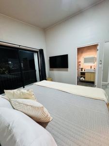 a bedroom with two beds and a flat screen tv at Stillness Suite - Tamarindo - Pinilla - Avellanas - Pool - BBQ in San José Pinilla