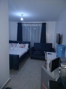 a living room with a bed and a couch at Cavendish Square Studio Unit, Syokimau in Syokimau