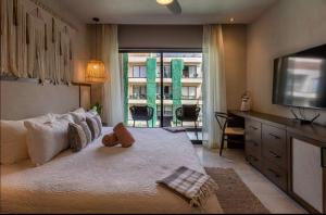 a bedroom with a large bed and a television at Bakal Luxury condos in Tulum