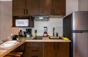 a kitchen with wooden cabinets and a stainless steel refrigerator at Bakal Luxury condos in Tulum