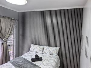a bedroom with a bed with a black and white striped wall at 1 at Gurnard in Newlands