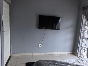 a flat screen tv hanging on a white wall at 1 at Gurnard in Newlands