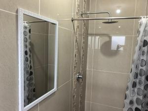 a shower with a mirror and a shower curtain at 1 at Gurnard in Newlands