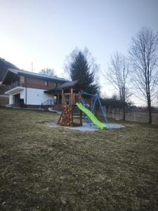 a playground with a slide in a yard at EDEN HOUSE Viseu de Sus in Vişeu de Sus