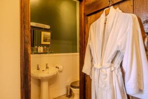 a white robe hanging in a bathroom with a sink at Cantre Selyf in Brecon +57 photos