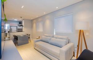 a living room with a couch and a kitchen at Apartamento Premium - Melhor vista de Curitiba in Curitiba