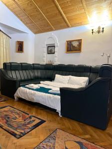 a black leather couch in a room with a bed at SpaOk & Play in Mărgăriţi