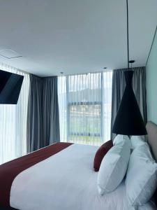 a bedroom with a bed with a large window at Hotel B3 Sibelius in Chía +4 photos