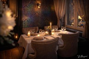 a table with candles and wine glasses in a restaurant at La Reine Hôtel & Restaurant in Spa +47 photos