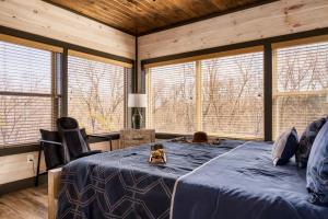 a bedroom with a bed in a room with windows at Open Skydeck with Spectacular View and Hot Tub in Sevierville