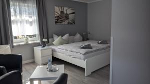 a bedroom with a bed and a living room at Hotel Villa Fröhlich in Baabe
