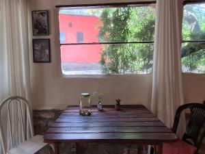 a wooden table in a room with a window at Bela Oyá Casa Hostel in Vale do Capao
