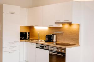 a kitchen with white cabinets and a counter top at Wohnen bei frau tinz - Apartment - Bahnhof- und Zentrumsnähe in Neunkirchen