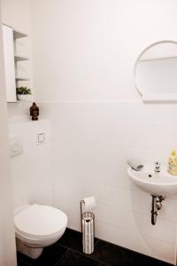 a white bathroom with a toilet and a sink at Wohnen bei frau tinz - Apartment - Bahnhof- und Zentrumsnähe in Neunkirchen +5 photos