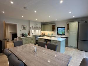 a large kitchen with a wooden table and chairs at East Barn Bed & Breakfast in Wall