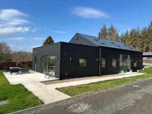 a black house on the side of a road at East Barn Bed & Breakfast in Wall